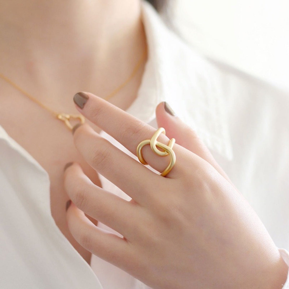 Gekruiste ring met geometrisch vloeiend design en glanzend mat goud